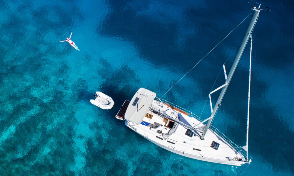 amazing view to yacht, swimming woman and clear water - caribbean paradise